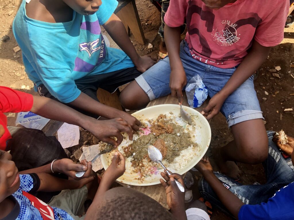 大きな皿のご飯を食べる少年たち